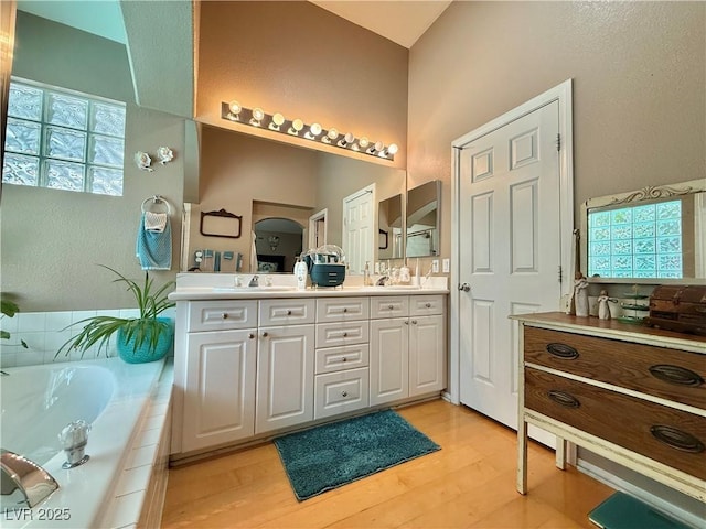 2986 Matese Dr, Henderson, NV 89052 - full bath featuring double vanity, a sink, a bath, and wood finished floors