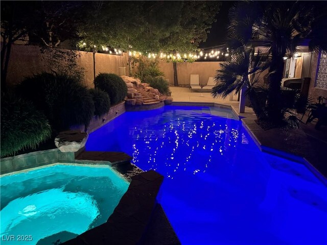 2986 Matese Dr, Henderson, NV 89052 - pool at night featuring fence and a pool with connected hot tub