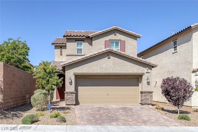 view of front of home with stucco siding, a tiled roof, fence, driveway, and stone siding