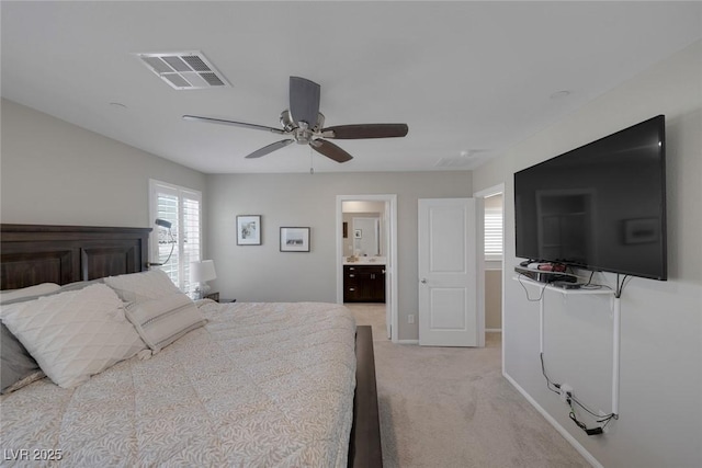 bedroom featuring ensuite bath, light carpet, baseboards, visible vents, and a ceiling fan
