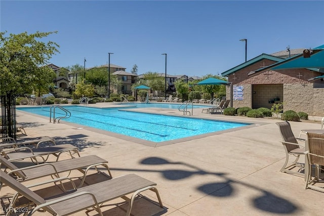 community pool featuring fence and a patio area