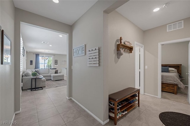 hall with light tile patterned flooring, visible vents, recessed lighting, and baseboards