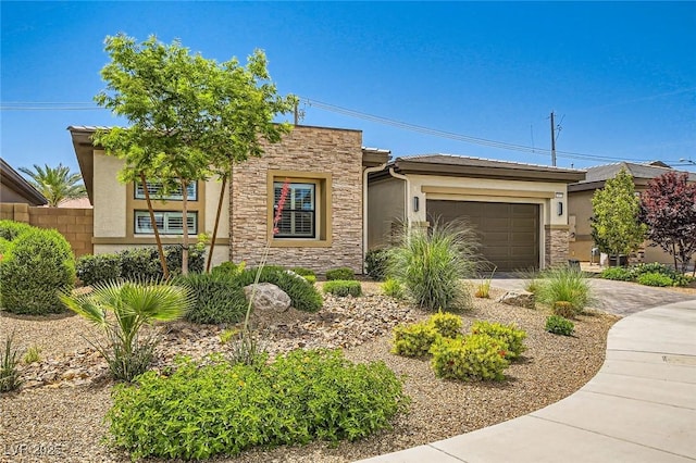 view of front facade featuring a garage, stucco siding, concrete driveway, and stone siding