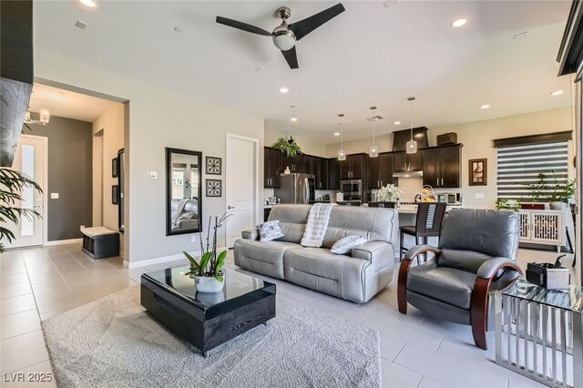 living room with recessed lighting, baseboards, light tile patterned floors, and ceiling fan with notable chandelier