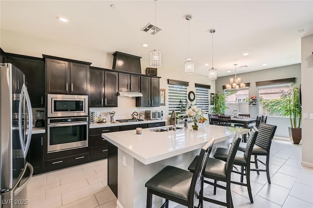 kitchen with visible vents, a sink, light tile patterned floors, light countertops, and stainless steel appliances