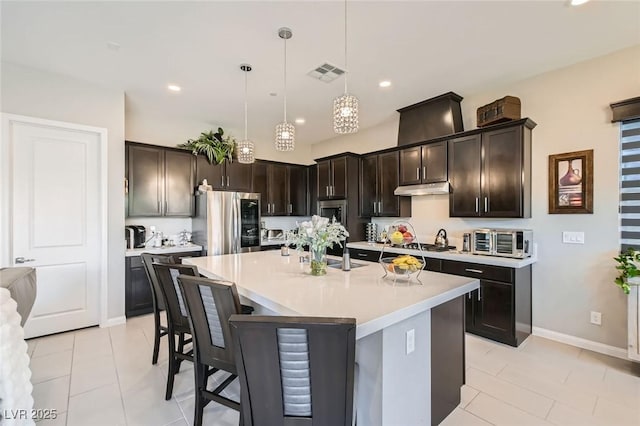 kitchen with visible vents, dark brown cabinets, smart refrigerator, a center island with sink, and light countertops