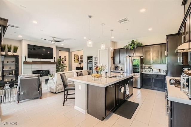 kitchen with visible vents, smart refrigerator, a sink, light countertops, and open floor plan