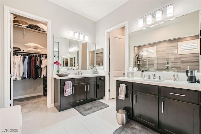 full bathroom featuring tile patterned flooring, a sink, a walk in shower, and two vanities