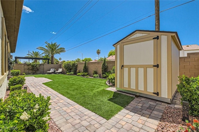 view of yard with a storage shed, an outdoor structure, a fenced backyard, and a patio area