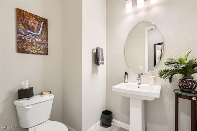 bathroom with baseboards and toilet