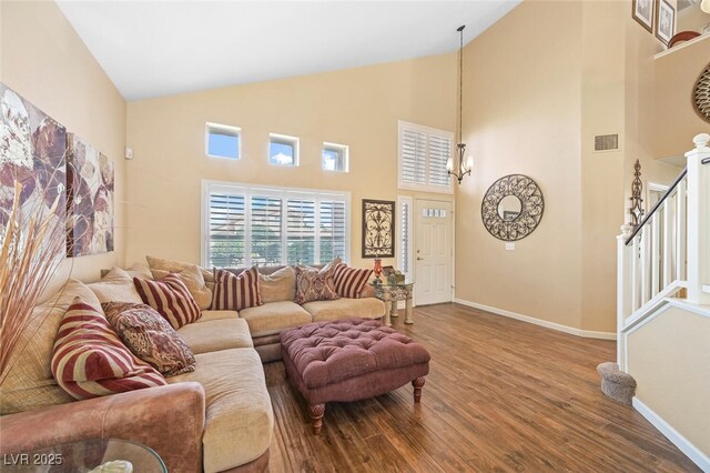 3295 Cooper Creek Dr, Henderson, NV 89074 - living area with high vaulted ceiling, stairs, visible vents, baseboards, and wood finished floors