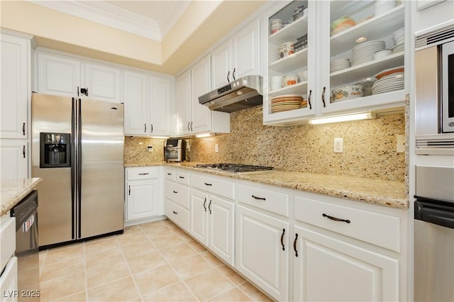 kitchen with tasteful backsplash, under cabinet range hood, ornamental molding, stainless steel refrigerator with ice dispenser, and gas cooktop