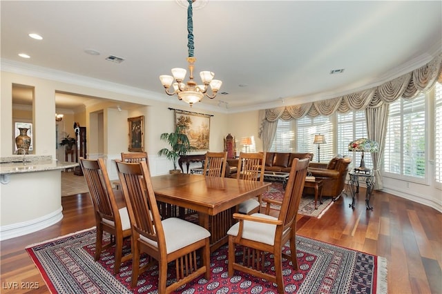 dining area featuring ornamental molding, an inviting chandelier, and visible vents