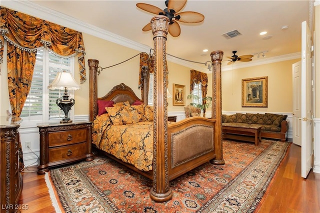 bedroom with recessed lighting, wood finished floors, a wainscoted wall, visible vents, and crown molding