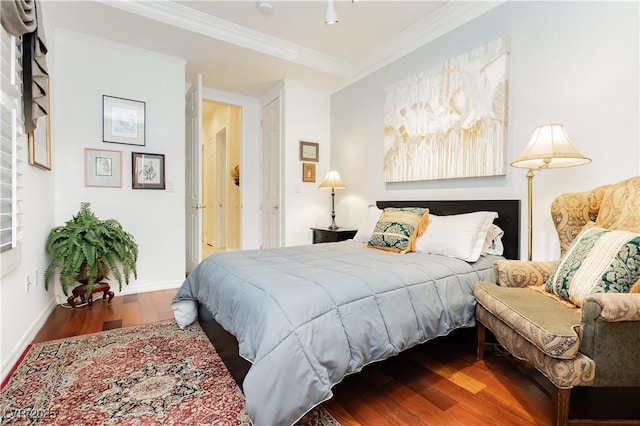 bedroom with baseboards, wood finished floors, and crown molding