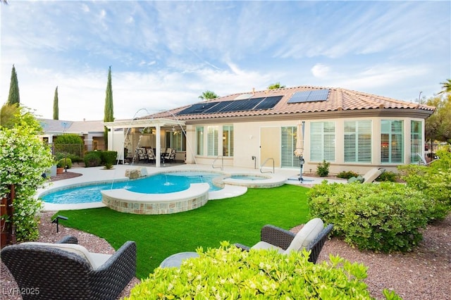 back of property featuring a patio, a yard, a fenced backyard, a tiled roof, and roof mounted solar panels