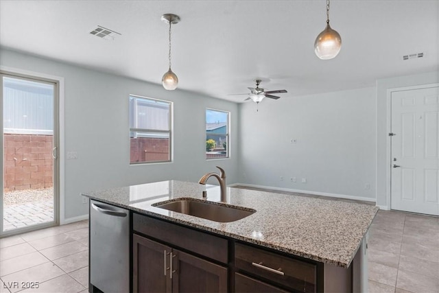 kitchen with a sink, stainless steel dishwasher, decorative light fixtures, and dark brown cabinetry