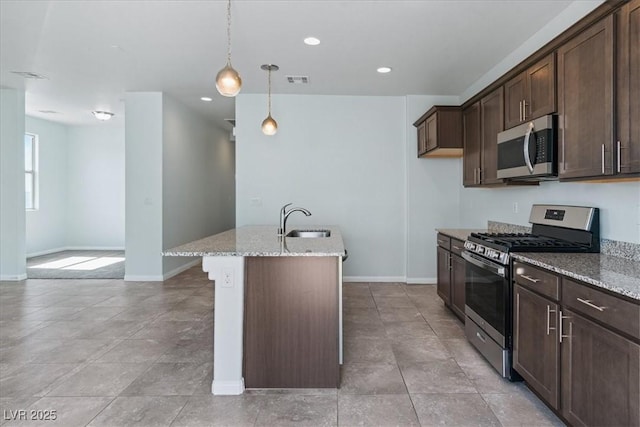 kitchen with appliances with stainless steel finishes, light stone counters, baseboards, dark brown cabinets, and decorative light fixtures