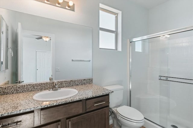 full bath featuring toilet, a shower stall, and vanity