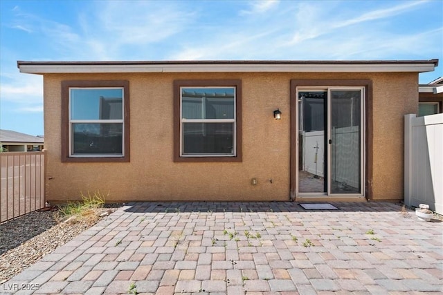 back of house featuring a patio area, stucco siding, and fence
