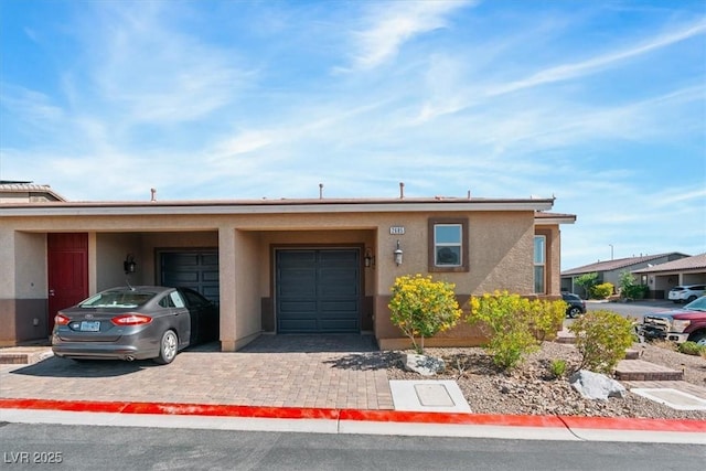 view of front of property with a garage, decorative driveway, and stucco siding