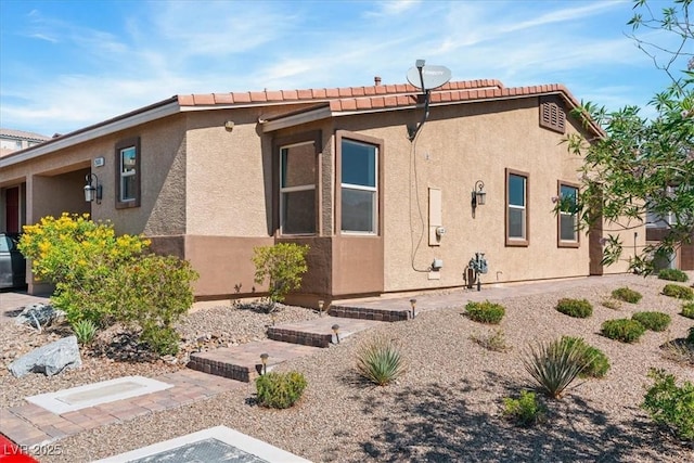 view of home's exterior featuring stucco siding and a tiled roof