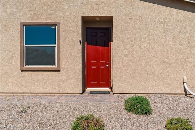 entrance to property featuring stucco siding