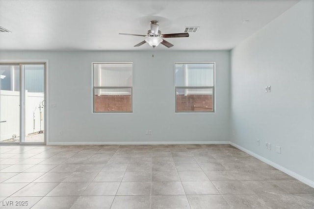 empty room featuring ceiling fan, baseboards, and tile patterned flooring