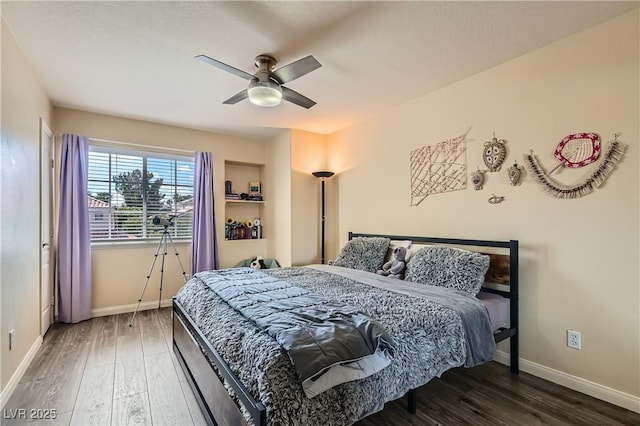 bedroom featuring wood finished floors, baseboards, and a ceiling fan