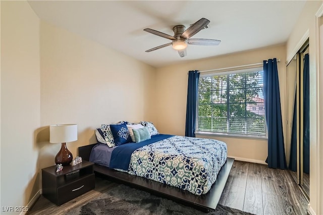 bedroom with wood finished floors, baseboards, ceiling fan, and a closet