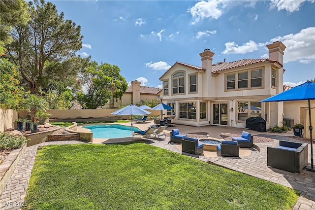 rear view of house with a fire pit, a patio area, stucco siding, a chimney, and a tiled roof