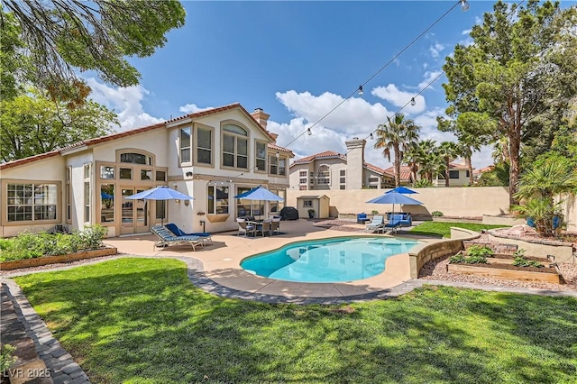 view of pool with a patio area and a garden