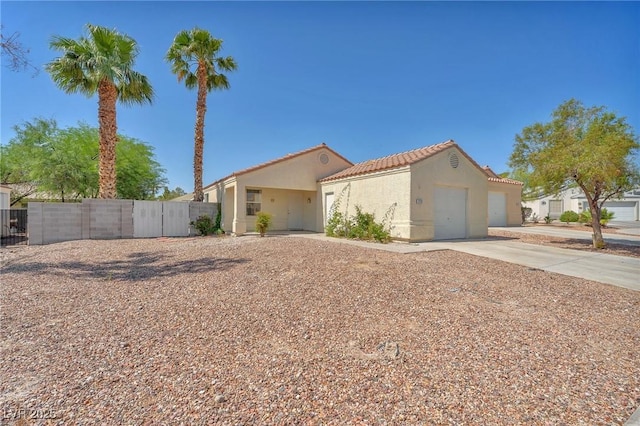 719 Roberta Alecia Ave, North Las Vegas, NV 89031 - mediterranean / spanish-style home featuring stucco siding, a tiled roof, a garage, concrete driveway, and a gate