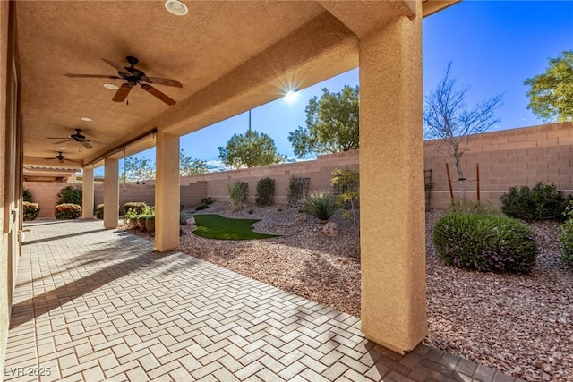 8797 Pinley Spring St, Las Vegas, NV 89113 - fenced backyard with ceiling fan and a patio area