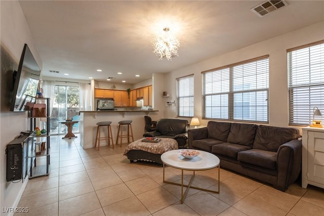 living room featuring recessed lighting, a notable chandelier, visible vents, and light tile patterned floors