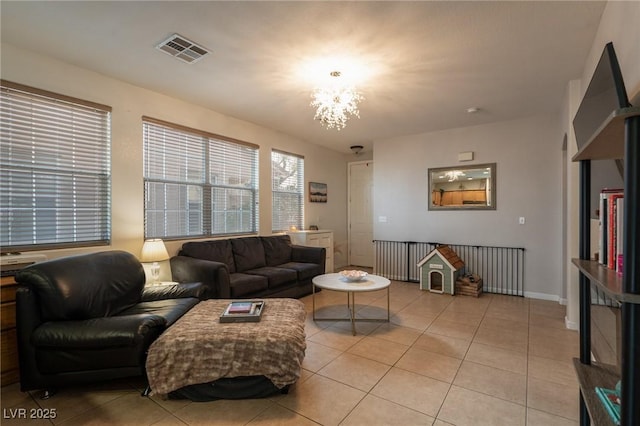 living area featuring light tile patterned flooring, a notable chandelier, and visible vents