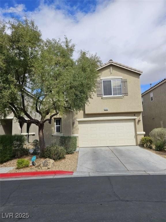 view of front of home featuring concrete driveway, an attached garage, and stucco siding