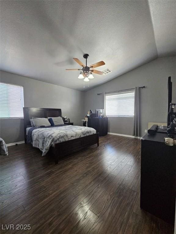 bedroom featuring dark wood finished floors, ceiling fan, baseboards, visible vents, and lofted ceiling