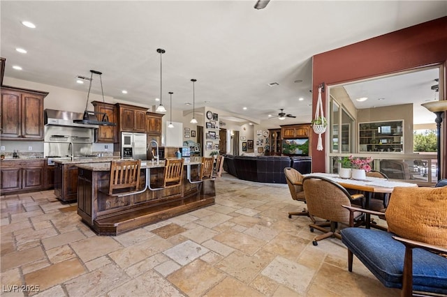 1981 Trophy Elk Ave, Logandale, NV 89021 - kitchen featuring recessed lighting, stainless steel fridge, dark brown cabinetry, a large island with sink, and open floor plan