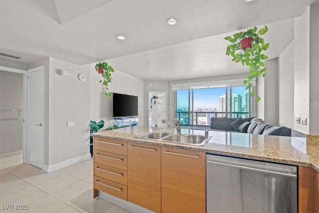 kitchen featuring a sink, baseboards, open floor plan, light stone countertops, and dishwasher
