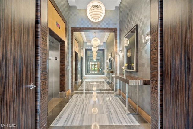 hallway with an inviting chandelier and elevator