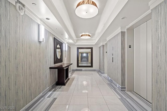 corridor with a tray ceiling and baseboards