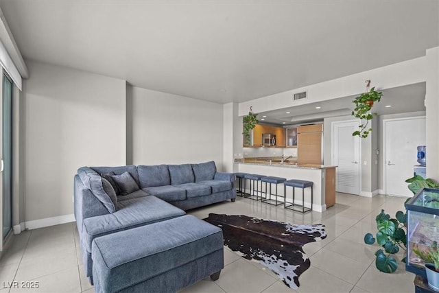 living area with light tile patterned floors, recessed lighting, visible vents, and baseboards