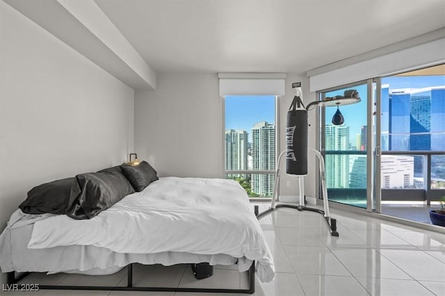 bedroom featuring a view of city, baseboards, and tile patterned floors