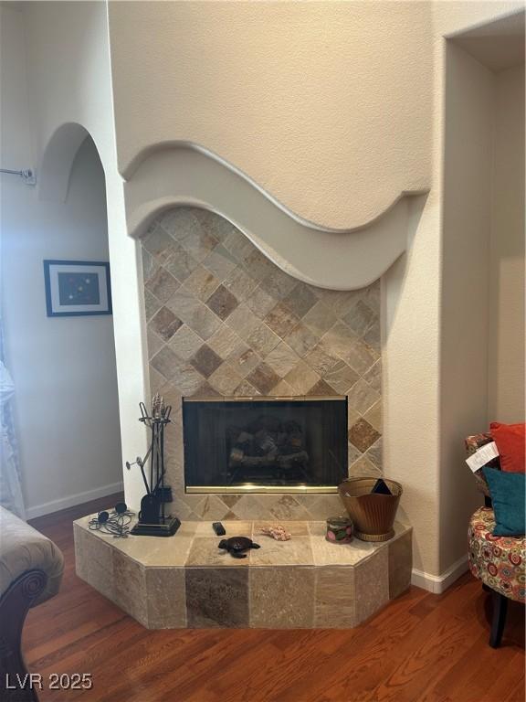 interior details with a fireplace, wood finished floors, and baseboards