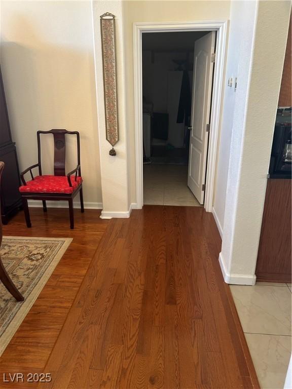hallway with baseboards and wood finished floors