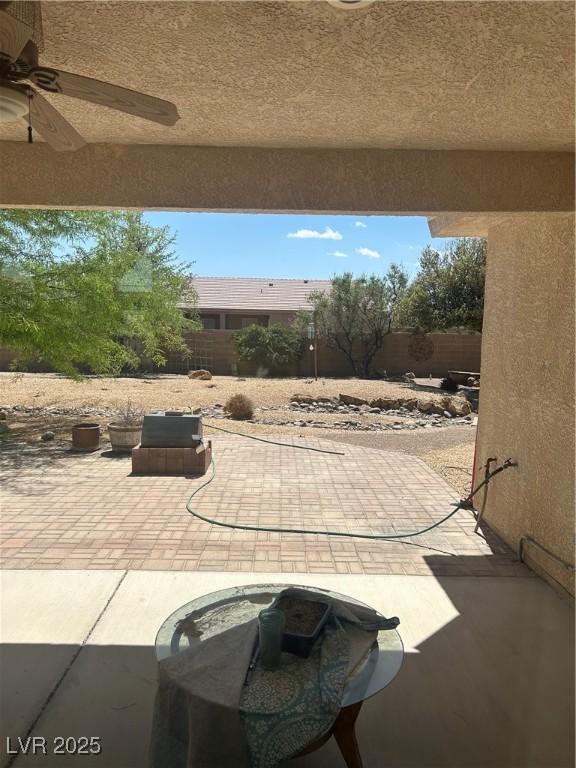 view of patio with a fenced backyard and a ceiling fan