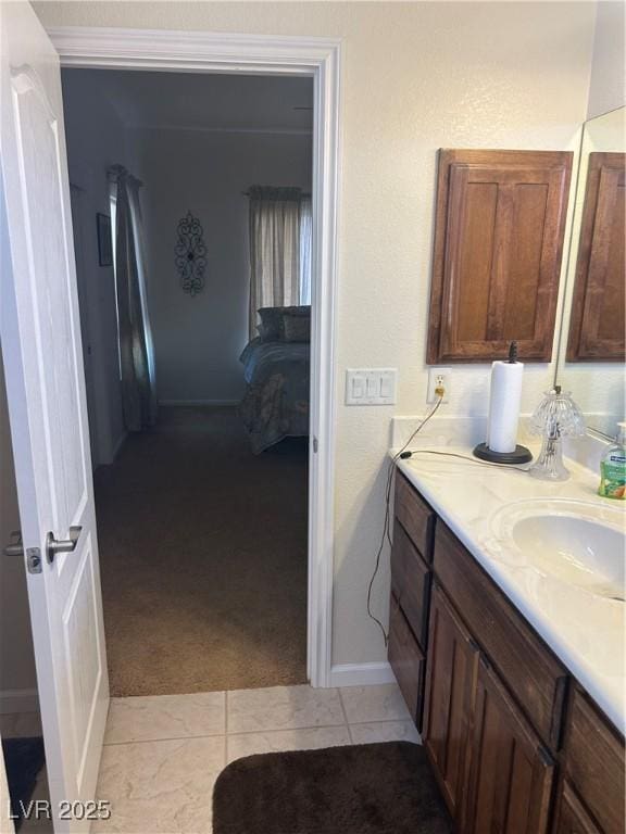 bathroom with vanity, baseboards, ornamental molding, tile patterned flooring, and ensuite bathroom