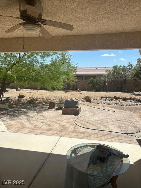 view of patio with ceiling fan and fence
