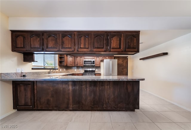 711 Sari Dr, Las Vegas, NV 89110 - kitchen with appliances with stainless steel finishes, a peninsula, dark brown cabinets, light tile patterned floors, and backsplash